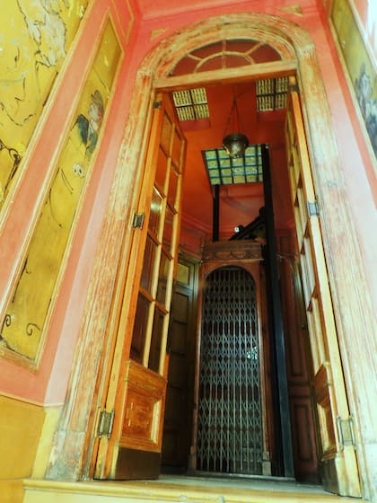 Colorido ingreso y el centenario ascensor, fuera de uso.