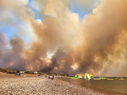 Columnas de humo de un incendio forestal suben hacia el cielo en la isla de Rodas, Grecia, el sábado 22 de julio de 2023. (Rhodes.Rodos via AP)