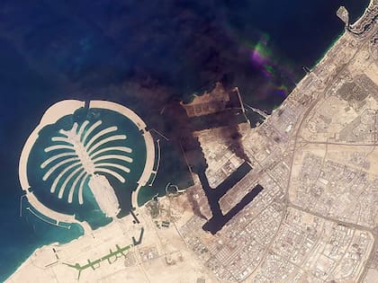Columnas de humo elevándose al lado de la icónica "palmera" de Dubai tras el impacto de un proyectil iraní