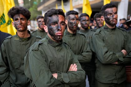 Combatientes de Hezbollah asisten a una procesión fúnebre de dos de sus compañeros que murieron por artillería israelí, el martes 10 de octubre de 2023, en el poblado de Khirbet Selm, en el sur de Líbano. El grupo respaldado por Irán anunció la noche del lunes que tres de sus elementos fallecieron luego de un intenso ataque de Israel en contra de localidades fronterizas en el sur de Líbano. 