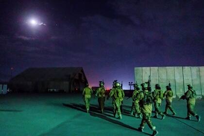 Combatientes talibanes de la unidad Fateh Zwak, empuñando armas, equipo y uniformes suministrados por los estadounidenses, irrumpen en el Aeropuerto Internacional de Kabul para asegurar el aeropuerto e inspeccionar el equipo que quedó atrás después de que el Ejército de los EE. UU. completó su retirada