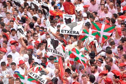 Los participantes revolean banderas antes del comienzo de la ceremonia el festival de San Fermín