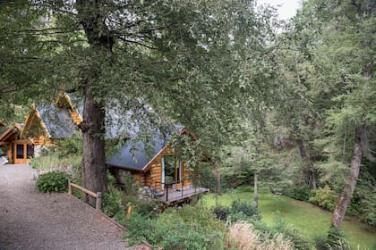Como en los cuentos, la casa de madera se deja entrever entre el verde espeso de los árboles.