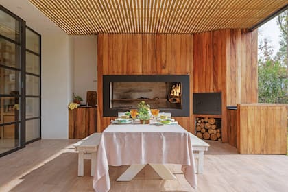 Como la interiorista Rocío Pinasco eligió rodear la parrilla con madera (Tauro Muebles) debió proteger el material del humo y el calor encuadrándo el hueco con un grueso marco de chapa.
