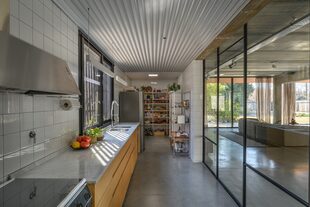 Como mobiliario, eligieron un bajomesada y agregaron espacio de guardado extra con una estantería que hace de despensa a la vista.