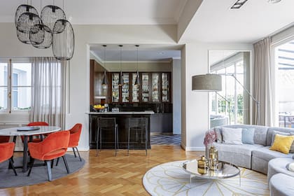 En el comedor formal, mesa y sillas (Créole) y lámparas colgantes de hierro "Nature" (Alvar Iluminación). En la barra, banquetas de Increa.