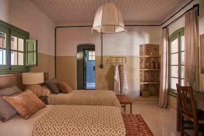 Como un juego de estampas, el techo cuadriculado se acompañó con pies de cama estampados y otro empapelado floreado en un nicho de la pared.