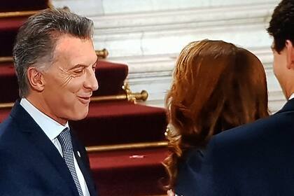 Como un nene, Macri se ríe mientras saluda con la boca llena a su par canadiense