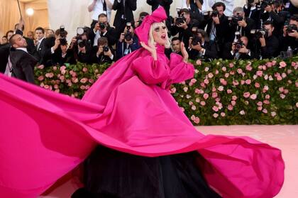 Como un solo diseño no le alcanzaba, durante la noche de la MET Gala 2019 Lady Gaga hizo cuatro cambios de vestuario. Sin embargo, el más impactante fue el primero. La cantante desembarcó en la alfombra roja con un imponente vestido fucsia. Las mangas campana XL, la eterna capa, la maxifalda y el moño en la cabeza con el que completó el look resaltan y le dieron aún más vuelo a la personalidad arrolladora de la artista