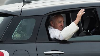Como una estrella de rock, Francisco saluda desde el automóvil al llegar a Filadelfia ayer. Un modesto Fiat negro