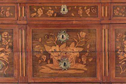 Cómoda francesa de época Luis XVI enchapada en nogal. El mobiliario forma parte de la valiosa colección de la Embajada. 