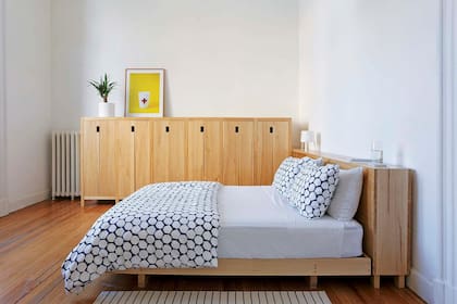 Cómoda, respaldo-baúl y cama de álamo (Paraná Muebles) con fundas y acolchado estampados (Ikea). Lámpara de plástico ‘Tvärs’ y alfombra rayada (ambos, Ikea).