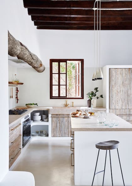 Completan la escena los muebles de madera blanqueada y un tronco al natural como terminación del volumen que contiene el extractor.