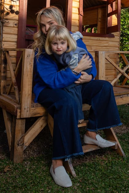 Cómplices y divertidas, madre e hija hacen morisquetas mientras miran a cámara.
