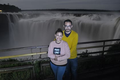 Comprometidos, Santiago y Natali se abrazan con las Cataratas, iluminadas por la luna, de fondo