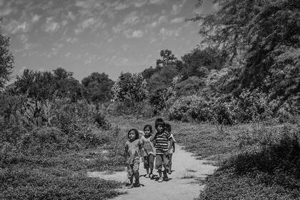 Un grupo de chicas y chicos de la comunidad de Teniente Fraga; todos andan descalzos