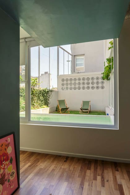 Con buen criterio, la pileta se ve y se siente desde todos los ángulos de la casa. Reposeras (Confort y Muebles)