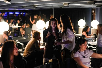 Con cortinados de pana azul, el interiorismo del bar se destaca por el mobiliario de autor