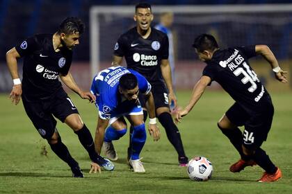 Con el apoyo de Ángel Romero, Julián Palacios maneja la pelota frente a Juan Aguilar; San Lorenzo, un triunfo entre tanta incertidumbre