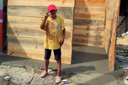 Con el brazo en alto, José agradece a quienes le regalaron una casa de madera y alimentos