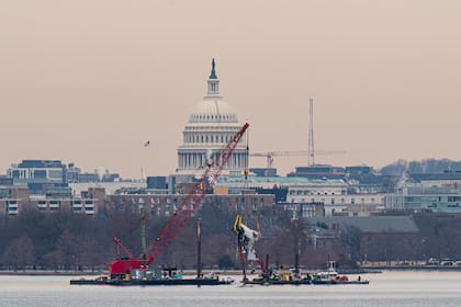 Con el Capitolio al fondo, una grúa levanta parte del fuselaje de los restos de un avión de American Airlines que se estrelló la semana pasada tras colisionar con un helicóptero Black Hawk en el río Potomac en Arlington, Virginia, el 3 de febrero de 2025.