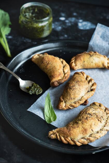 Con el resto de recortes de masa de tarta que van sobrando de las preparaciones, y que pueden conservarse en el freezer, pueden hacerse empanadas. En este caso, con hongos de cultivo, borrajas silvestres y un toque ahumado con provola y especial con pesto.
