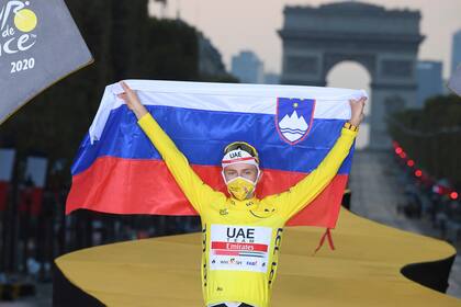 Con la bandera de su país, el esloveno Tadej Pogacar festeja su mayor triunfo