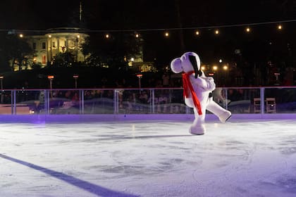 Con la Casa Blanca decorada para las festividades navideñas al fondo, Snoopy patina sobre la pista de hielo de la Casa Blanca, ubicada en el patio sur del complejo, en 2023