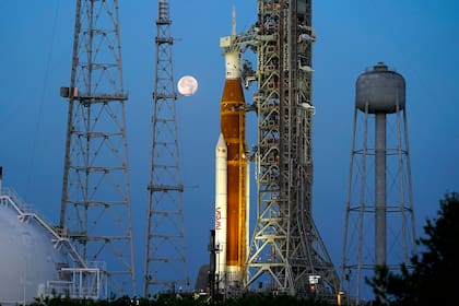 Con la Luna de fondo, el cohete del programa Artemisa de la NASA con la cápsula Orión en la parte superior permanece en la plataforma 39B del Centro Espacial Kennedy