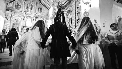 Con la tarde, bajan grupos de mujeres que se abren paso entre la gente y entran cantando a la iglesia