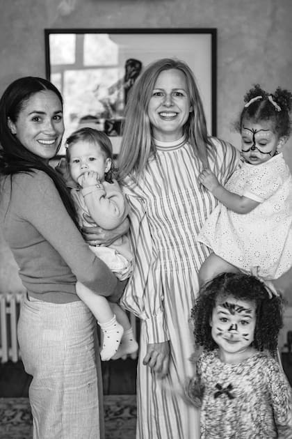 Con “Lili” en brazos, la duquesa de Sussex posa con Camilla Holmstroem, mujer del fotógrafo Misan Harriman, y sus dos hijas.