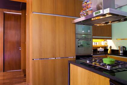 Con los metros justos, la cocina es sensacional. Tiene paneles de madera de un tinte dorado que esconden hasta las heladeras.