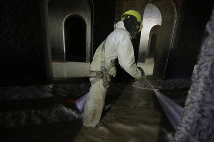 Con mangueras con alta presión se limpia los pisos, paredes y techos abovedados de los enormes reservorios