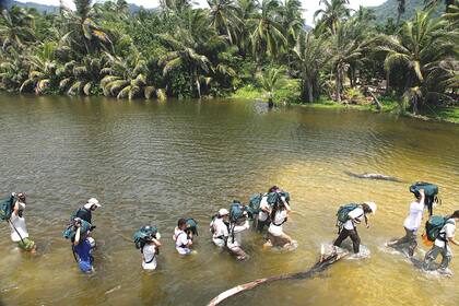 Con mochila. Los estudiantes cruzan a pie un río