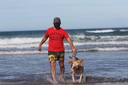 José Fiscina se permitió mojar sus pies en el mar. También los de su perro