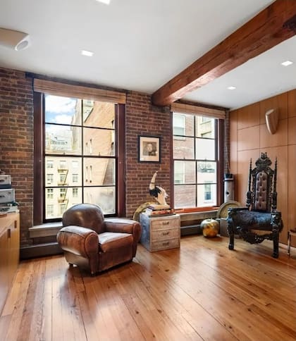 Con pisos de madera y ventanales de gran tamaño, el living destaca por su amplitud, luminosidad y la presencia de elementos originales de la construcción