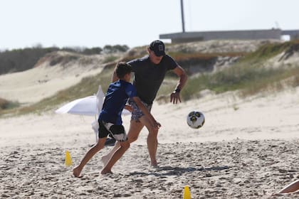 Con remera, gorrita y gafas para protegerse del sol, Sebastián Eskenazi juega al fútbol con su hijo y su sobrino 