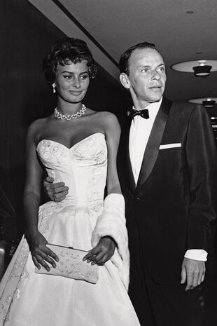 Con Sophia Loren, su compañera de set en Orgullo y pasión (1957), el día del estreno. La diva italiana fue la única que resistió el avasallante cortejo de Sinatra.
