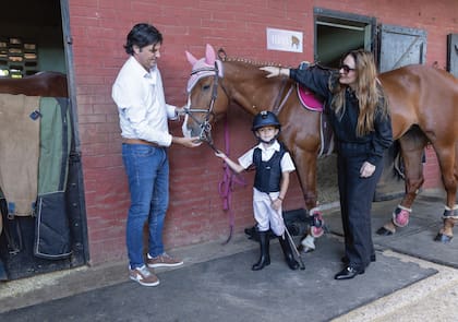 Con su casco y sus botas, la pequeña amazona
posa con su yegua –que lleva cubreorejas en color rosa a juego
con la manta– y sus padres, Nito Uranga y Sol Estevanez