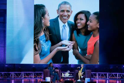 Con su marido, Barack Obama, y sus hijas, Malia y Sasha: durante el acto de lanzamiento de "Con luz propia", fotos y frases de Michelle, como “Te caes, te levantas, seguís”, encadenaron mensajes de superación y optimismo desde una gran pantalla