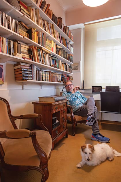 Con su puro y su perra Caty, en una de las bibliotecas del departamento que heredó de su padre Jaime, un fabricante de impermeables que fue dueño de todo el edificio.