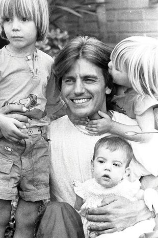 Con sus hermanos Federico y Victoria, que rodean a su papá mientras ella lo besa.