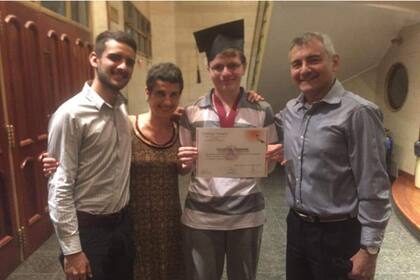 Con sus padres y su hermano el día en que recibió el título secundario, un logro cumplido con el apoyo de toda la familia.