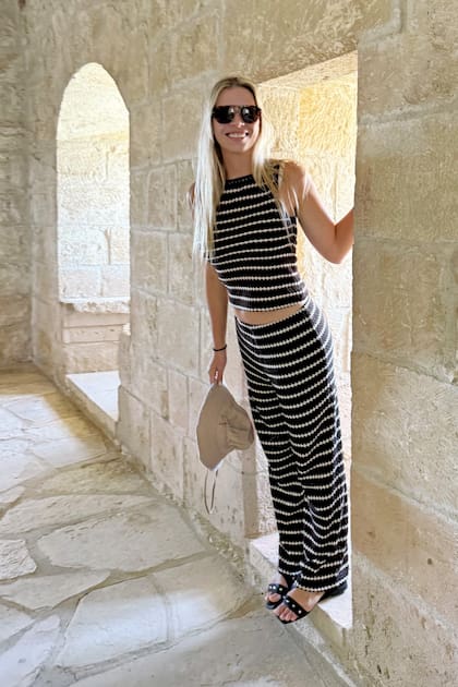 Con top y palazzo
a rayas, la modelo sonríe
durante la visita
a un castillo de
Chipre.