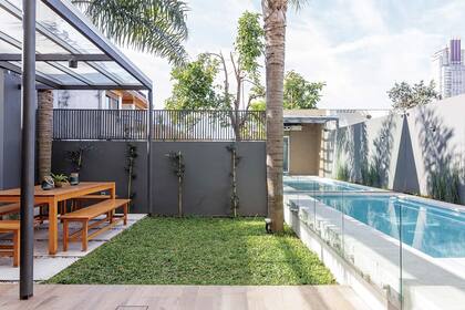 Afuera se rearmó la zona de parrilla y se incorporó una pileta hecha en altura para darles continuidad a las vistas desde el interior.