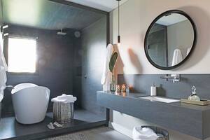 Con un halo tan magnético, en este baño el sector de la bañera y la ducha se distinguen sin necesidad de divisiones gracias a un recurso tan moderno como escenográfico.