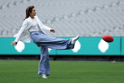 Con un look de pantalón de lino, pateó una pelota de fútbol australiano
