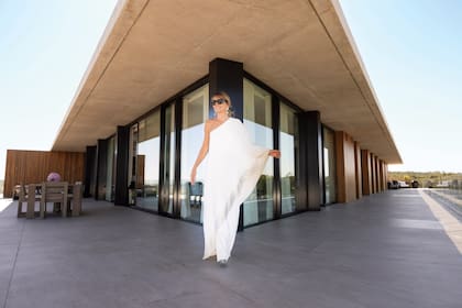 Con un vestido asimétrico de Óscar de la Renta, Patricia posa en la espectacular terraza de 300 metros cuadrados de su nuevo hogar ubicado en Manantiales. El complejo, The Colette Residences, fue construido en el mismo terreno donde antes se ubicaba el emblemático Hotel Las Dunas.