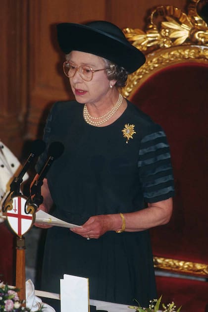 CON UNA FRASE DIJO TODO. En su discurso en el Guildhall de Londres (derecha) por el 40° aniversario de su reinado, Isabel II definió a ese año como “annus horribilis”.