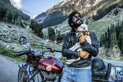 Con una ovejita en su viaje al cruzar el Himalaya